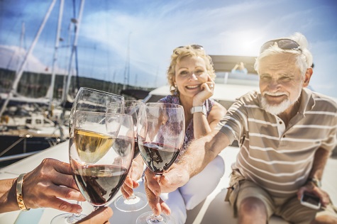 happy old couple drinking wine on royal albatross
